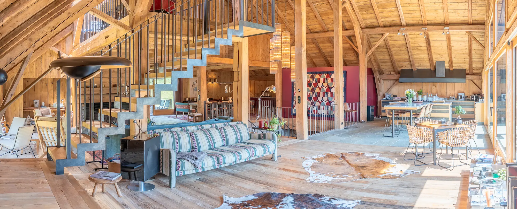 Vue panoramique du salon avec escalier en colimaçon et tapis en peau de vache
