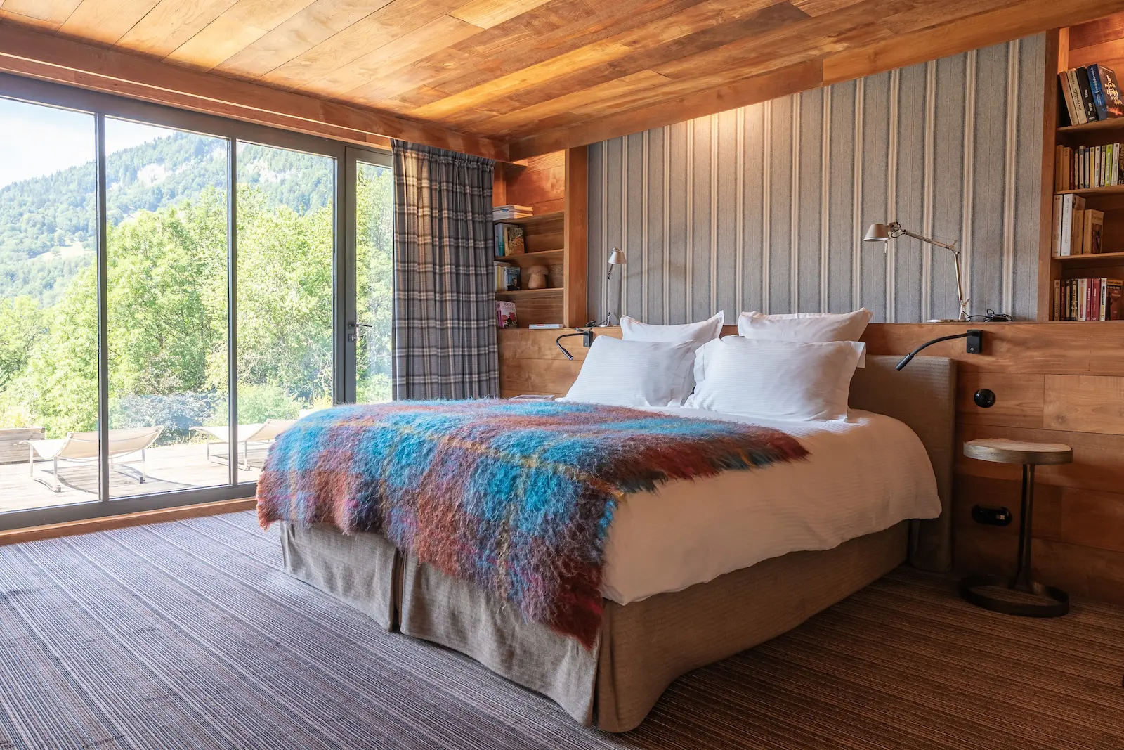 Chambre avec grande baie vitrée, bibliothèque et vue sur la vallée