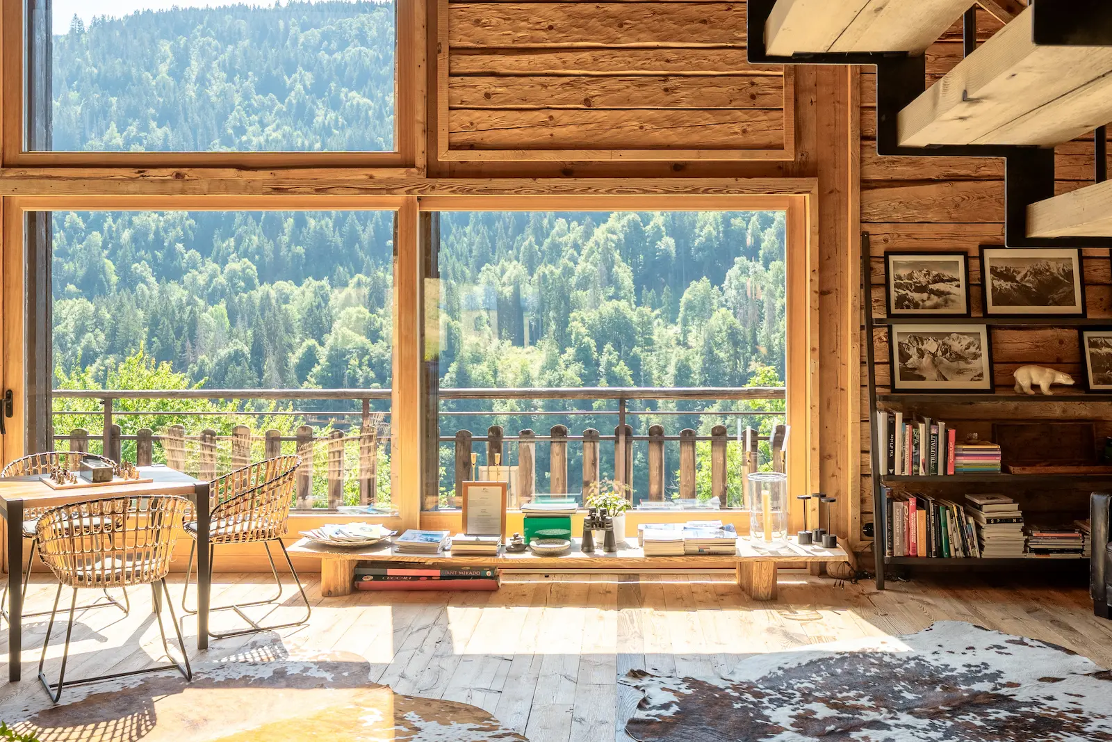 Coin bureau avec grandes baies vitrées donnant sur la forêt et tapis en peau de vache