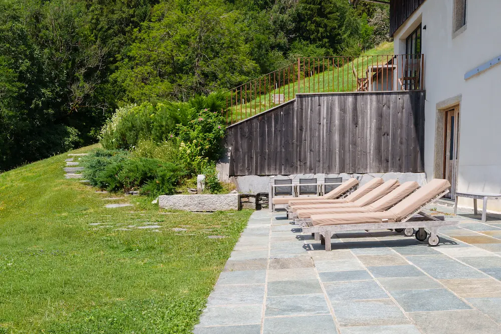 Solarium extérieur avec chaises longues en bois sur terrasse en pierre