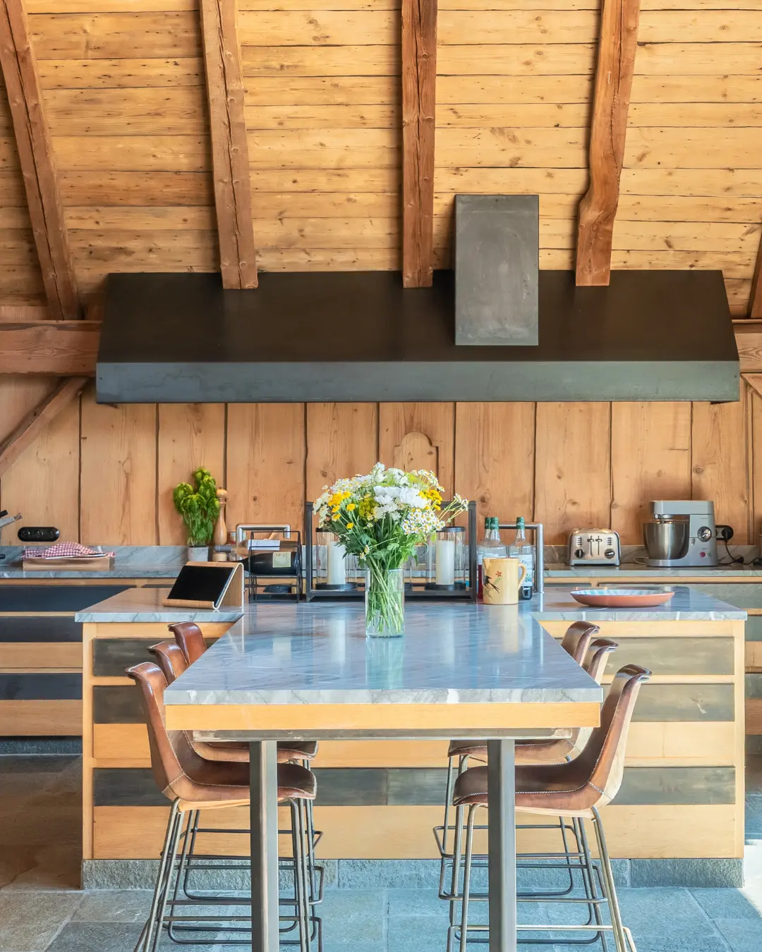 Îlot de cuisine avec plan de travail en pierre et tabourets