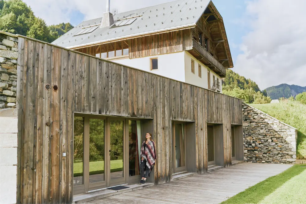 Façade extérieure du bâtiment l'Annexe en bois et pierre avec vue sur les montagnes