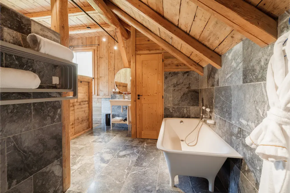 Suite Master – baignoire îlot sous charpente en bois avec peignoirs