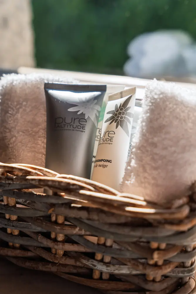 Chambre Chêne – panier en osier avec produits de bain Pure Altitude et serviettes