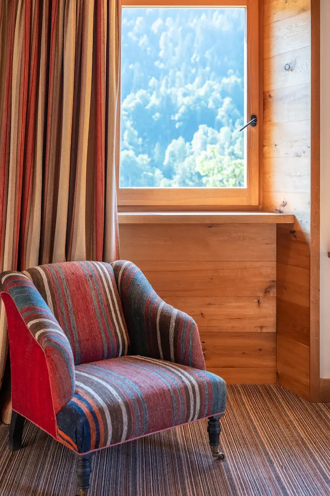 Chambre Chêne – fauteuil à rayures devant la fenêtre avec vue sur les montagnes