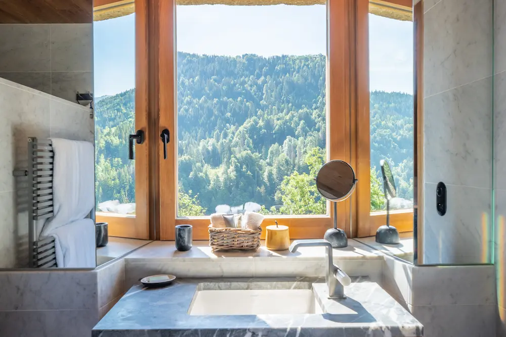 Chambre Chêne – vasque en marbre devant une fenêtre avec vue sur la forêt