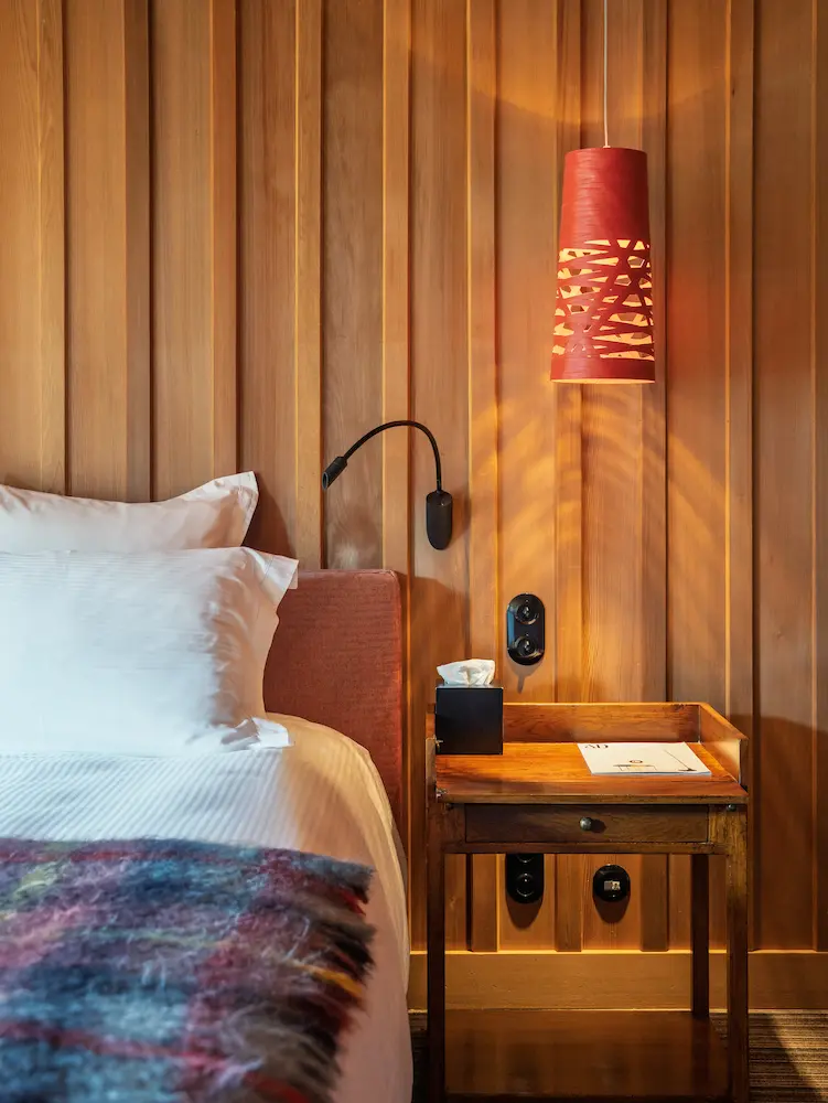 Chambre Red Cedar – table de chevet avec suspension rouge et lambris en bois