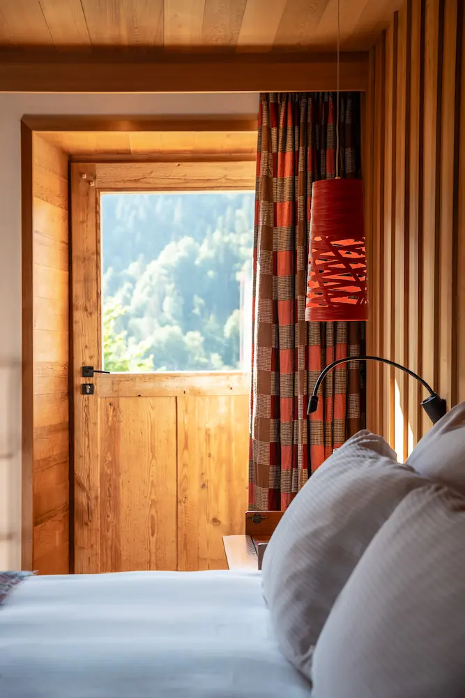 Chambre Red Cedar – porte d'entrée en bois et fenêtre avec vue sur la forêt