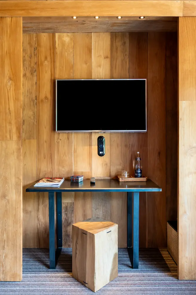 Chambre Teck – bureau intégré en bois avec téléviseur mural et tabouret cubique
