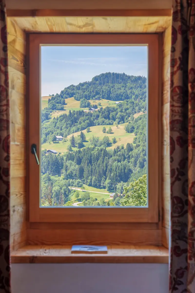 Chambre Vieux Bois – fenêtre en bois avec vue panoramique sur la vallée boisée